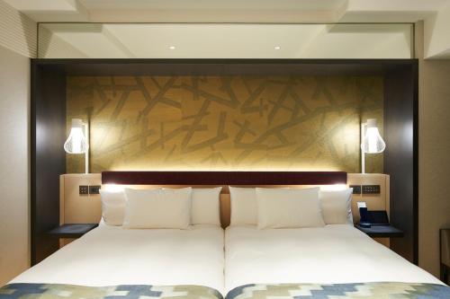 东京东京1899酒店的一间卧室配有一张大床和木制床头板