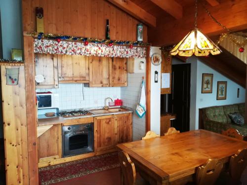 皮恩卡瓦罗Appartamento Piancavallo的厨房配有木制橱柜和木桌。