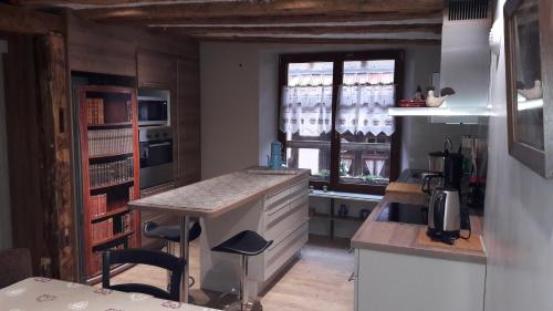 利克维Au fil de l'écriture - Appartement sur la Route des Vins à riquewihr的一个带柜台和窗户的小厨房