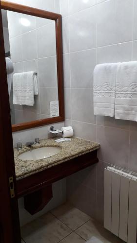 VacariaSan Bernardo Park Hotel的浴室配有盥洗盆、镜子和毛巾