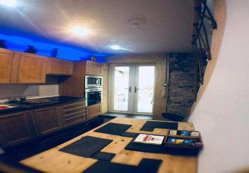 格文Ayrshire Holiday Cottage的厨房配有木桌和蓝色的灯光