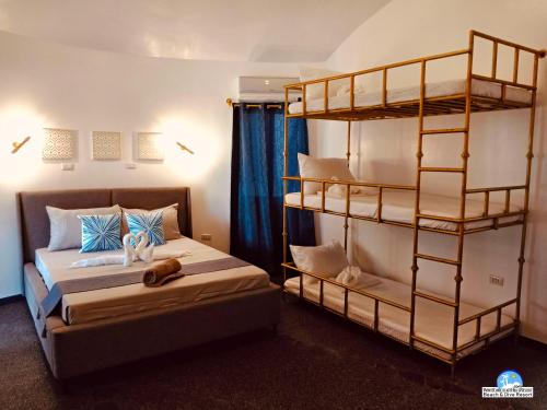 Zamboanguita白巧克力山度假村的一间卧室配有两张床和一张双层床。