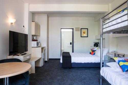 帕拉帕拉乌姆海滩U Studios Paraparaumu Beach的酒店客房配有一张床和一张双层床。