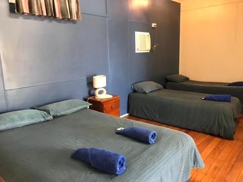 克朗克里Wagon Wheel Motel的客房设有两张带蓝色枕头的床。