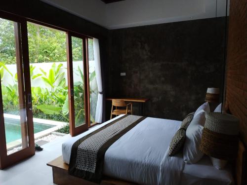 坎古La Isla Villas Bali的一间卧室设有一张床和一个大窗户