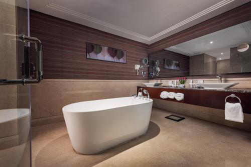 麦地那Rua Al Hijrah Hotel的一间带大浴缸和水槽的浴室