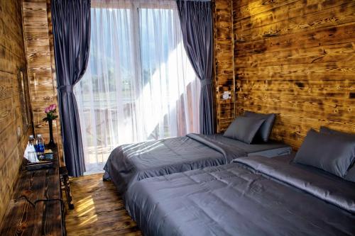 枚州县梅州乡村民宿的一间卧室设有两张床和大窗户