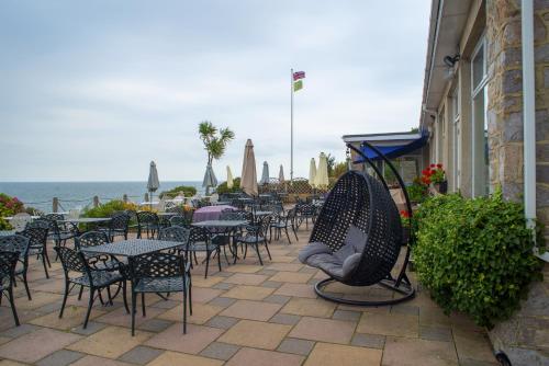 布里克瑟姆贝瑞海德酒店的一个带桌椅的庭院和大海
