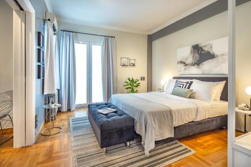 雅典Superb 1BD Apartment in the heart of Kolonaki by UPSTREET的一间卧室配有一张大床和一张沙发