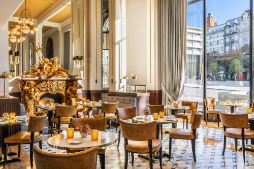 波尔图Maison Albar - Le Monumental Palace的一间带桌椅和壁炉的餐厅