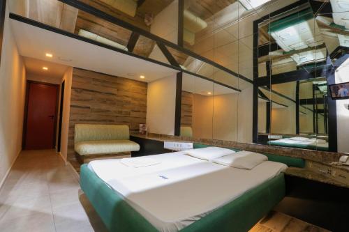里约热内卢Eden Hotel (Adults Only)的卧室配有一张白色大床和一把椅子