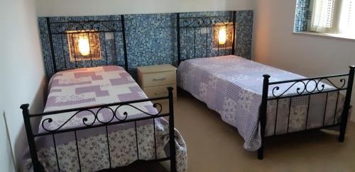 维耶斯泰Case Vacanze Fusillo Rosina的卧室设有两张单人床和两盏灯。