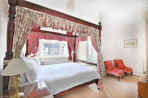 埃文河畔斯特拉特福弗吉尼亚旅馆的一间卧室设有天蓬床和窗户。