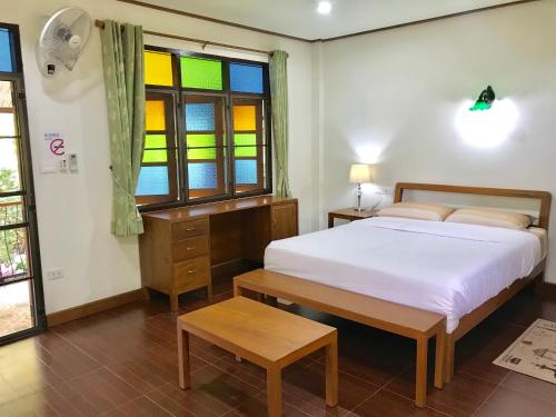 清迈Kawila126的一间卧室设有一张床和一个彩色玻璃窗