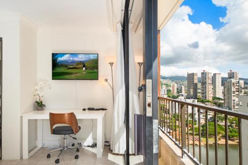 檀香山Royal Garden at Waikiki的客房设有书桌和景观阳台。