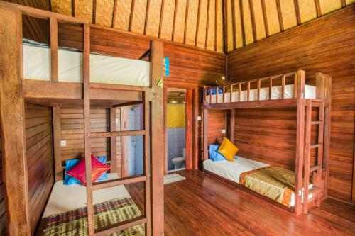 蓝梦岛Uma Hostel Lembongan的木墙客房的两张双层床