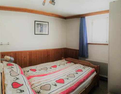阿罗萨Chalet Waldesruh 3 Zimmerwohnung的一间卧室配有一张床,床罩上带有心包