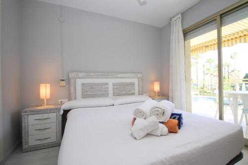 迈阿密普拉特亚ARENDA Apartamento Flamencos 213的一间卧室配有带毛巾的床和窗户。