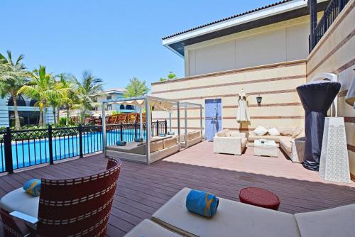 迪拜Zabeel Saray Royal Residences Lagoon Villa的一个带桌椅的庭院和一个游泳池