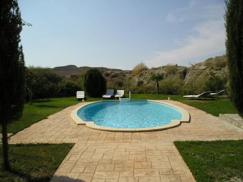 TardientaHotel Cueva Tardienta Monegros-Adults Only的院子里一个带两把椅子的游泳池