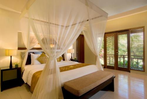 塞米亚克库贾别墅酒店的一间卧室配有一张带天蓬的床