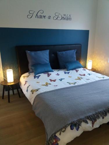 贝尔格Coté Cour的一间卧室配有一张蓝色墙壁的床和两盏灯。