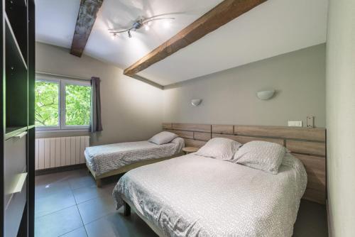 马赛杜金莎酒店的一间卧室设有两张床和窗户。