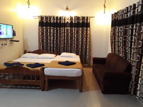 Kumta5 Mile Beach Resort的一间卧室配有一张床、一张沙发和一台电视