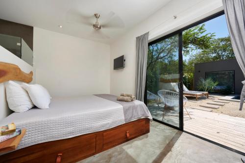 塔马林多Villa Ethir的一间卧室设有一张床和一个滑动玻璃门