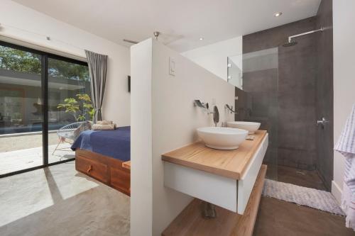 塔马林多Villa Ethir的一间带两个盥洗盆和淋浴的浴室以及一张床