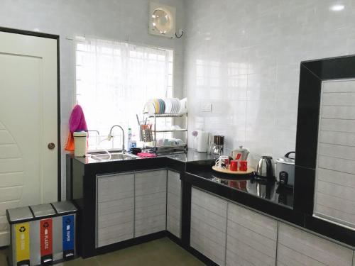 马六甲巴克卡迪因达旅舍的厨房配有黑色柜台和水槽