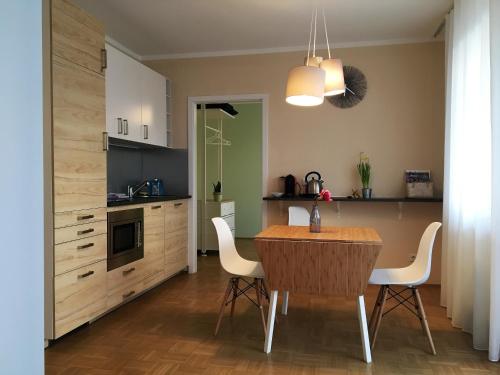 格拉茨Terrace by BestChoice - FREE Parking - Self Check-in的厨房配有木桌和白色椅子