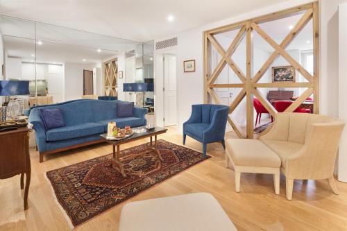 里斯本里斯本冷塔尔齐亚铎酒店的客厅配有蓝色的沙发和椅子
