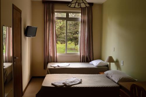 库里提巴贝塔尼亚旅馆的酒店客房设有两张床和窗户。