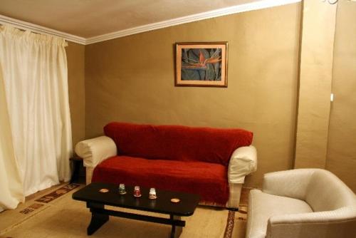 Curryʼs PostRugare Sweet Dreams Holiday Cottage的客厅配有红色的沙发和桌子
