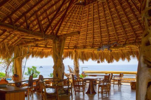 圣奥古斯蒂尼罗Cabañas Las 3 Marias的一间带桌椅的海景餐厅