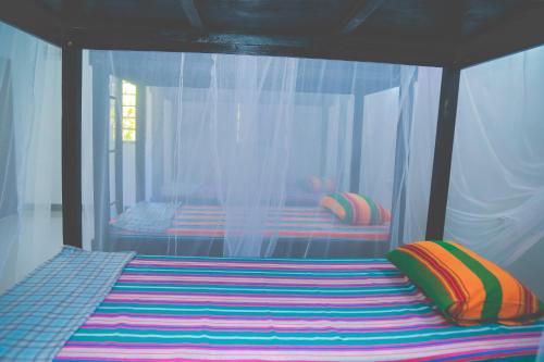 希克杜沃Hikka Surf Hostel的一张床上有色彩缤纷的枕头