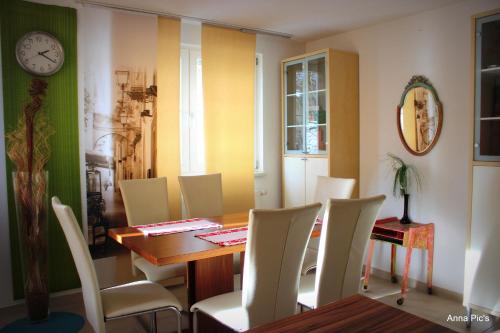 图特林根Donau Pension的一间带桌椅和时钟的用餐室