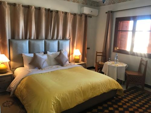 米德勒特米德勒特里亚德别墅酒店的一间卧室配有一张带黄色毯子的大床
