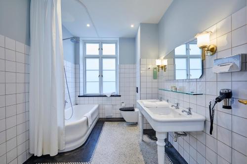 兰讷斯兰德斯酒店的一间带水槽、浴缸和卫生间的浴室