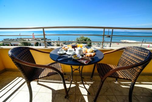 斯考里Hotel Panoramico的阳台上的餐桌和食物,享有海景