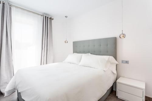 马贝拉by RIVA - Beautiful 1 Bedroom Chic Apartment in Banus Gardens的卧室内的白色床、白色床单和枕头