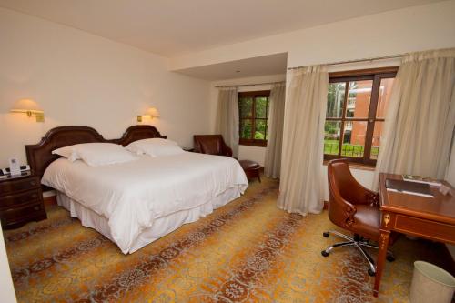 埃斯特角城巴拉达斯公园Spa酒店的酒店客房配有一张床、一张书桌和一张书桌。