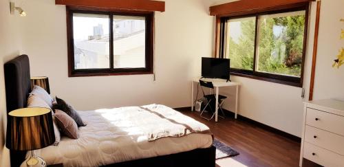 波尔图City Heart Rooms的一间卧室设有一张床和两个窗户。