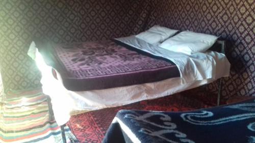 Foum ZguidBivouac Dune Iriki的一张带紫色床单和枕头的小床