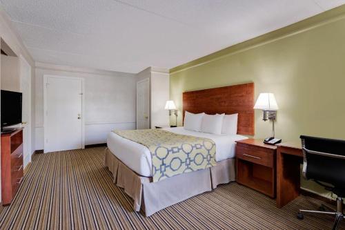 杰克逊维尔杰克逊维尔橘园拉金塔旅馆的酒店客房设有一张大床和一张书桌。