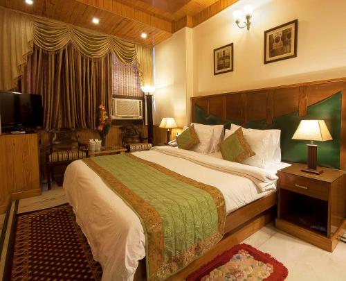 新德里木城堡酒店的一间卧室配有一张大床和电视