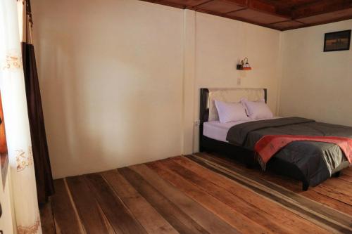 图克图克Laster Jony的的一间卧室配有一张床,铺有木地板