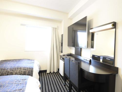水户水户市驿北APA酒店的酒店客房配有一张床和一张带镜子的书桌