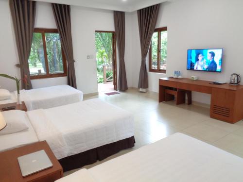 Ấp Phước CangVuon Xoai Resort的酒店客房设有两张床和一台平面电视。